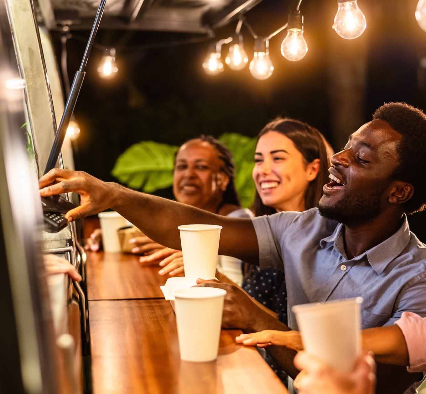 Young Man performing a Tap and Pay transaction at a food truck.